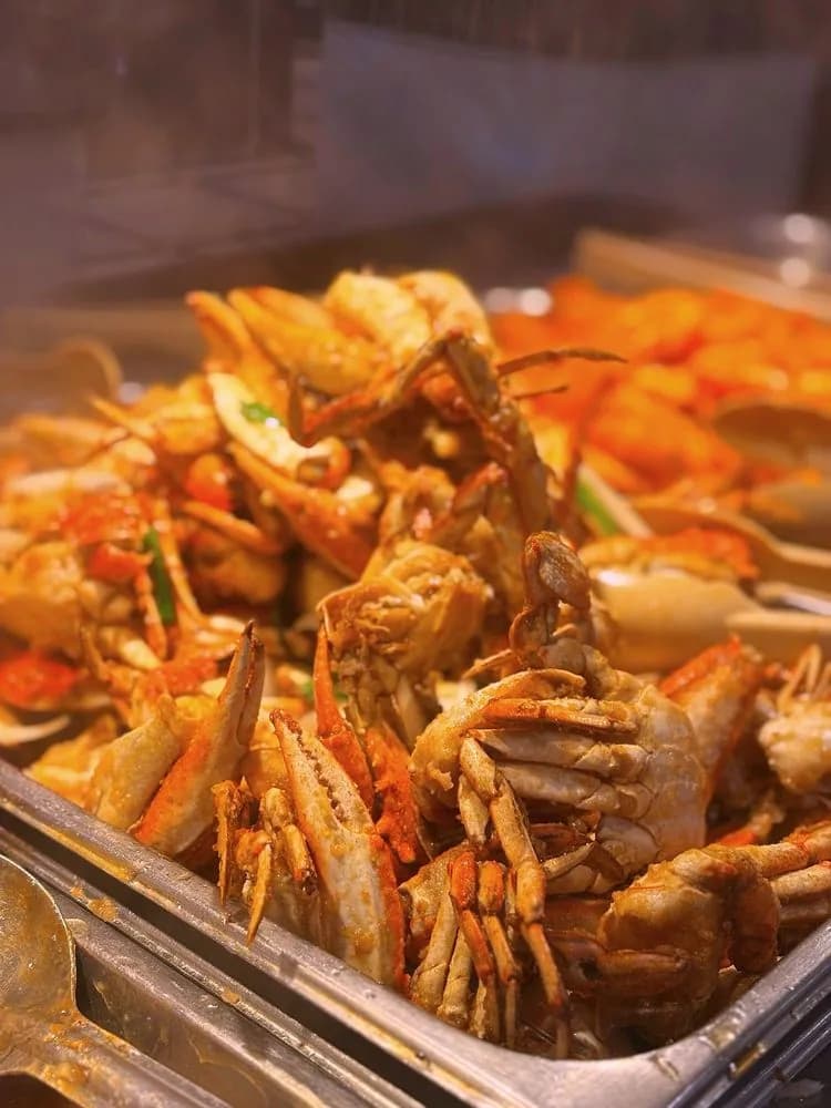 A tray of whole crab cooked with salt, pepper and scallions on the hot line