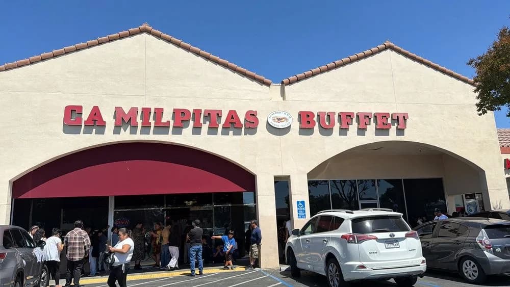 Diners waiting outside the entrance of CA Milpitas Buffet on a sunny afternoon