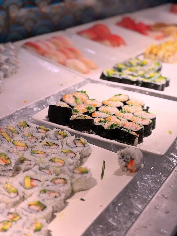 Plates of nigiri and maki rolls laid out on the chilled sushi bar